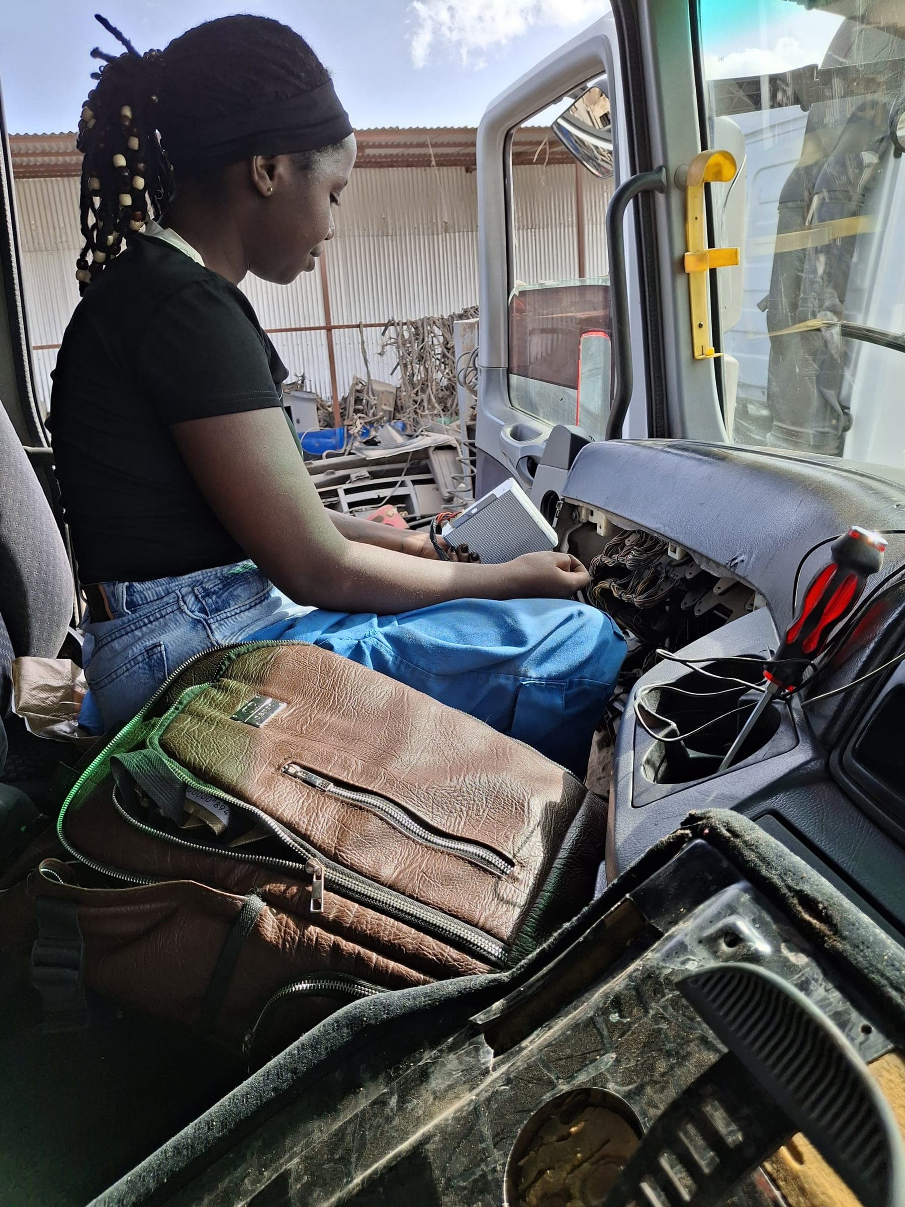 Technician wiring speed limiter electronics into truck dashboard