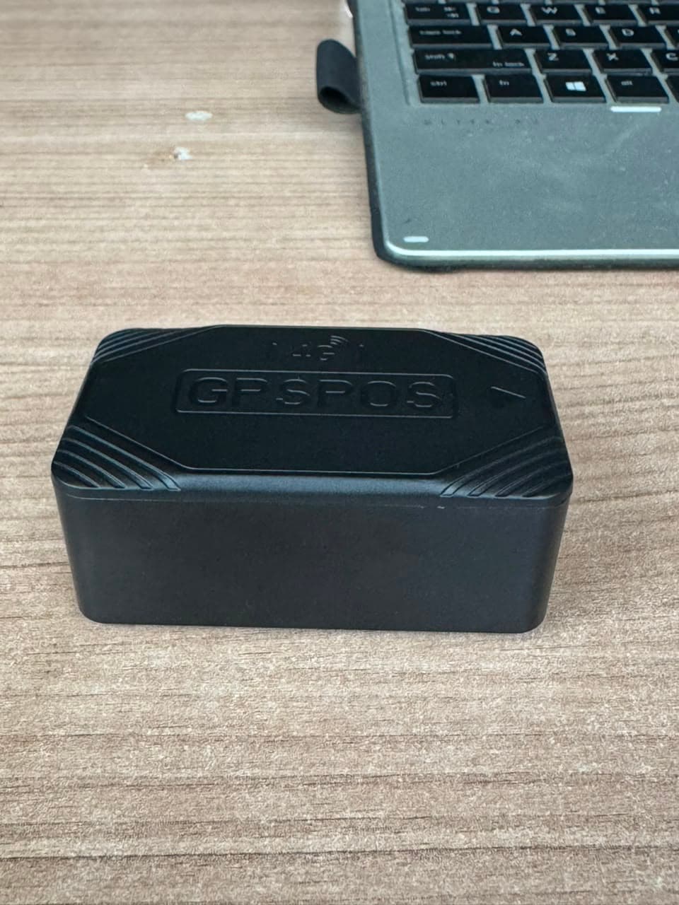 Side profile of a GPSPOS 4G vehicle tracker on a workbench during setup